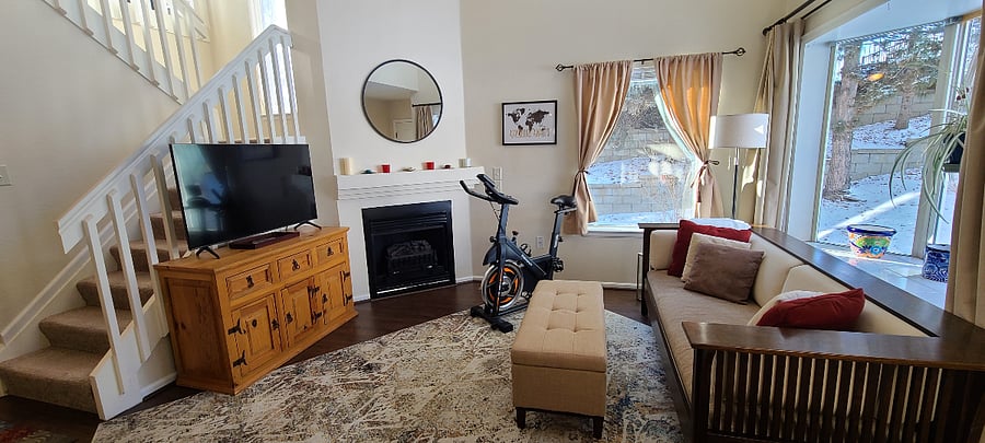 Cozy living room includes smart TV, electric fireplace, exercise bike and yoga mats, and warm natural light!