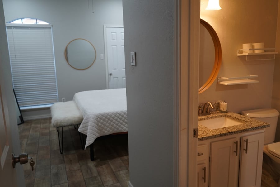Master Bedroom with flatscreen and walk in closet. Private Bathroom sink and toilet area