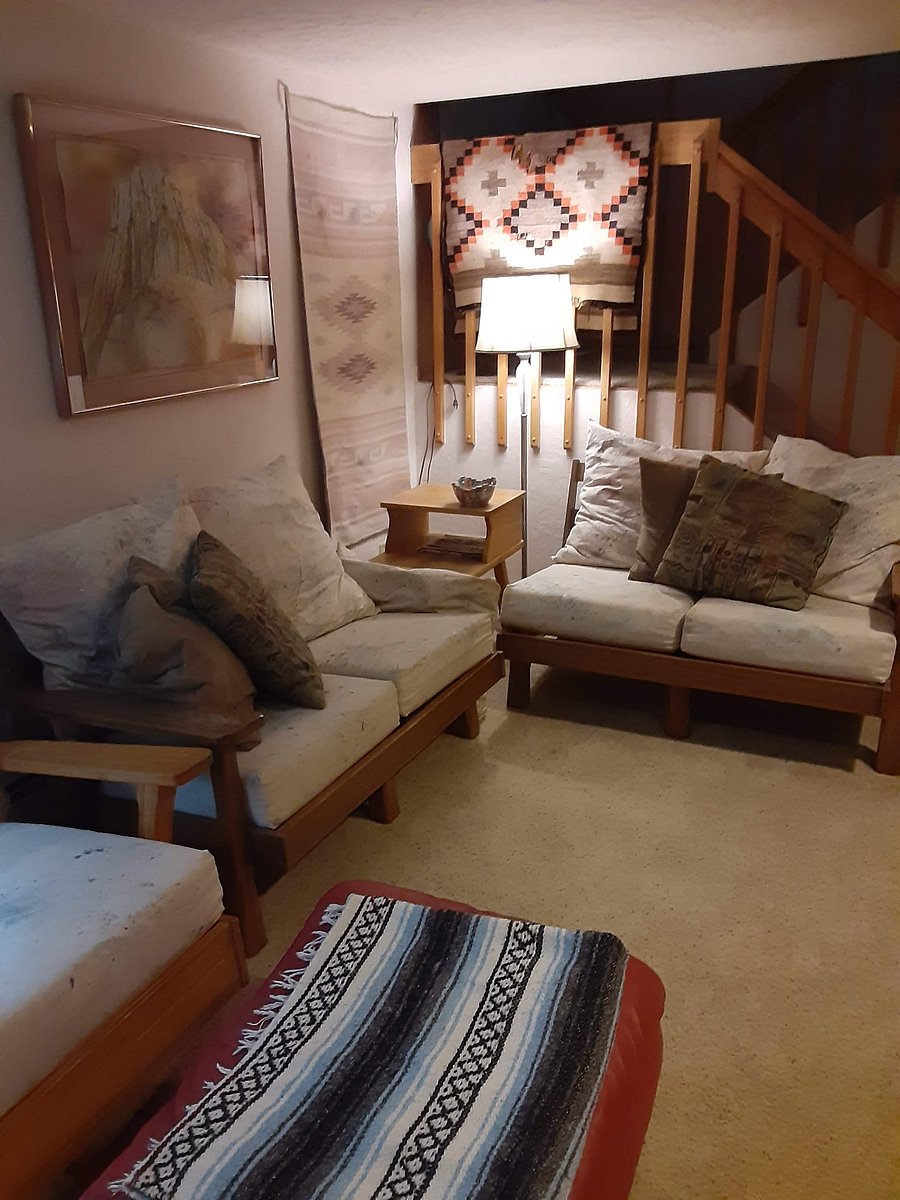 Living room area at bottom of stairs, light comes in from upstairs windows