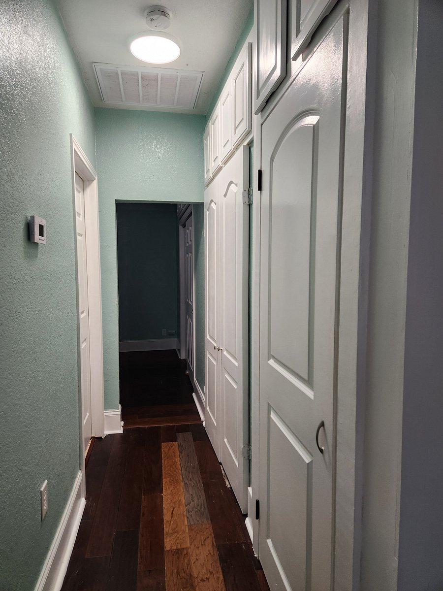Hallway from front room to theater room. Storage cabinets on right.