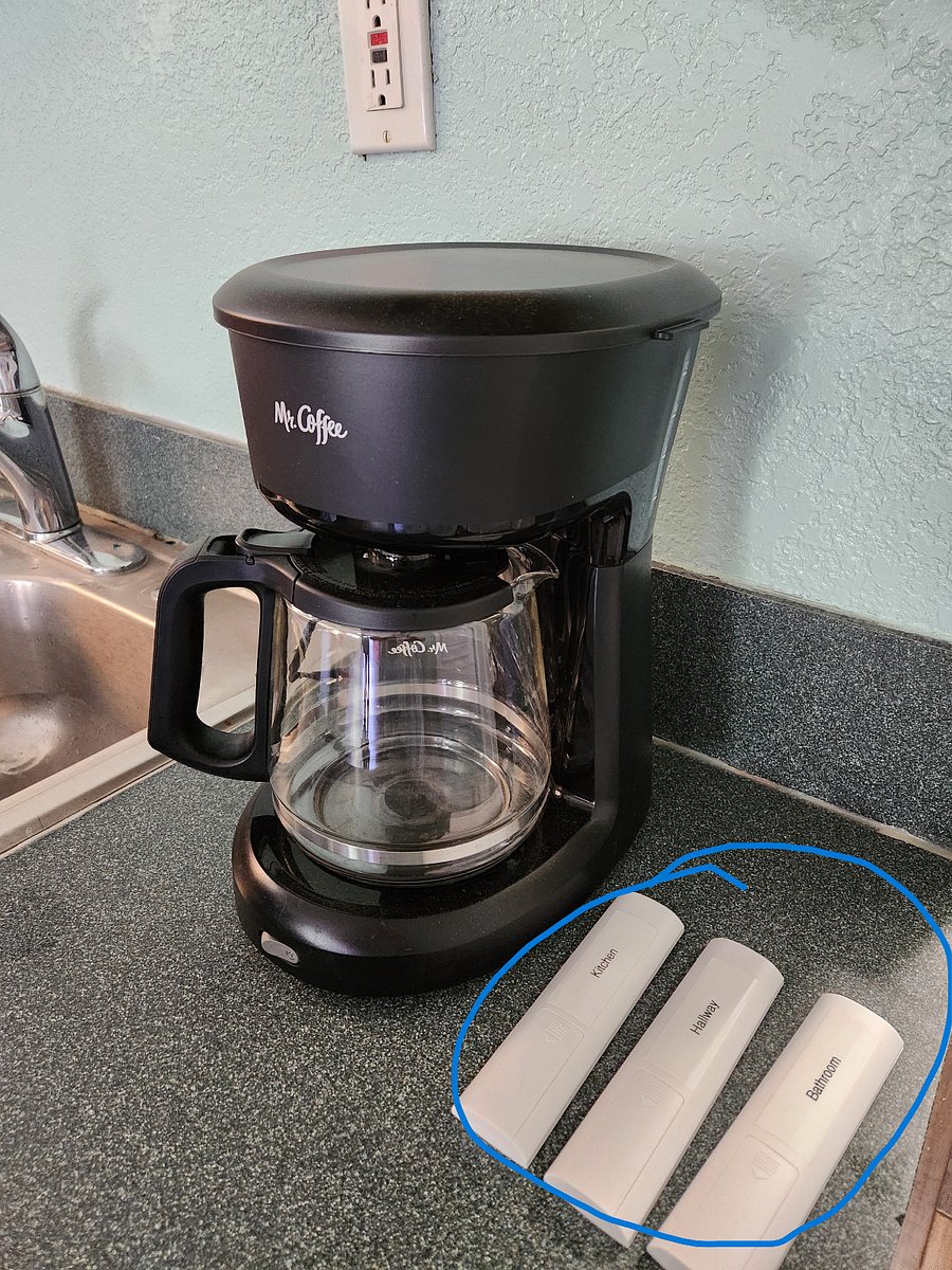 Coffee machine next to remotes for lighting.