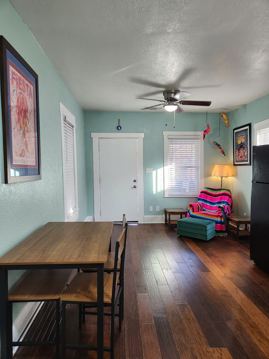 Front room with cozy spot, kitchen table, kitchen area.