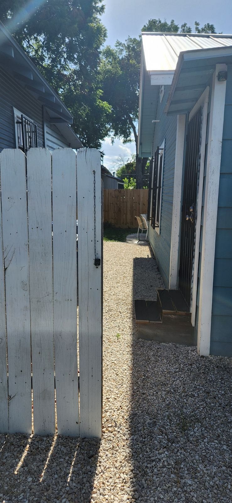 Looking from driveway into back yard. Gate closes and can be locked, and back door opens into private back yard.