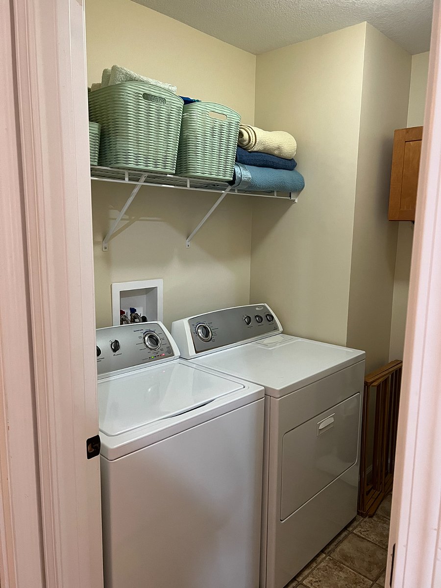 laundry room with washer/dryer, drying rack, hamper and built in storage.