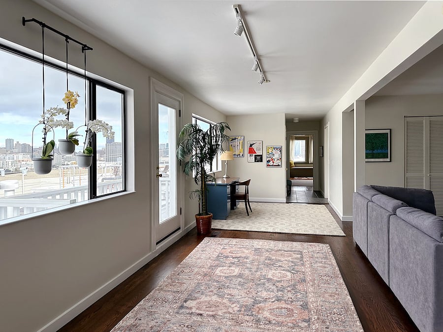 The glass door leads out to the small balcony. The desk is pictured too. 
