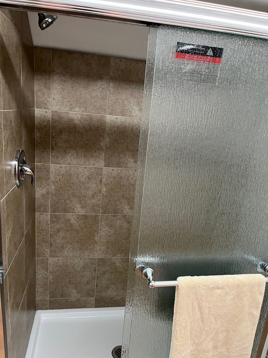 Shower has glass shower doors. 