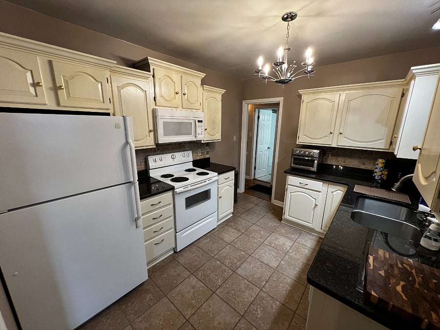 Kitchen with full fridge, oven, dishwasher, and disposal