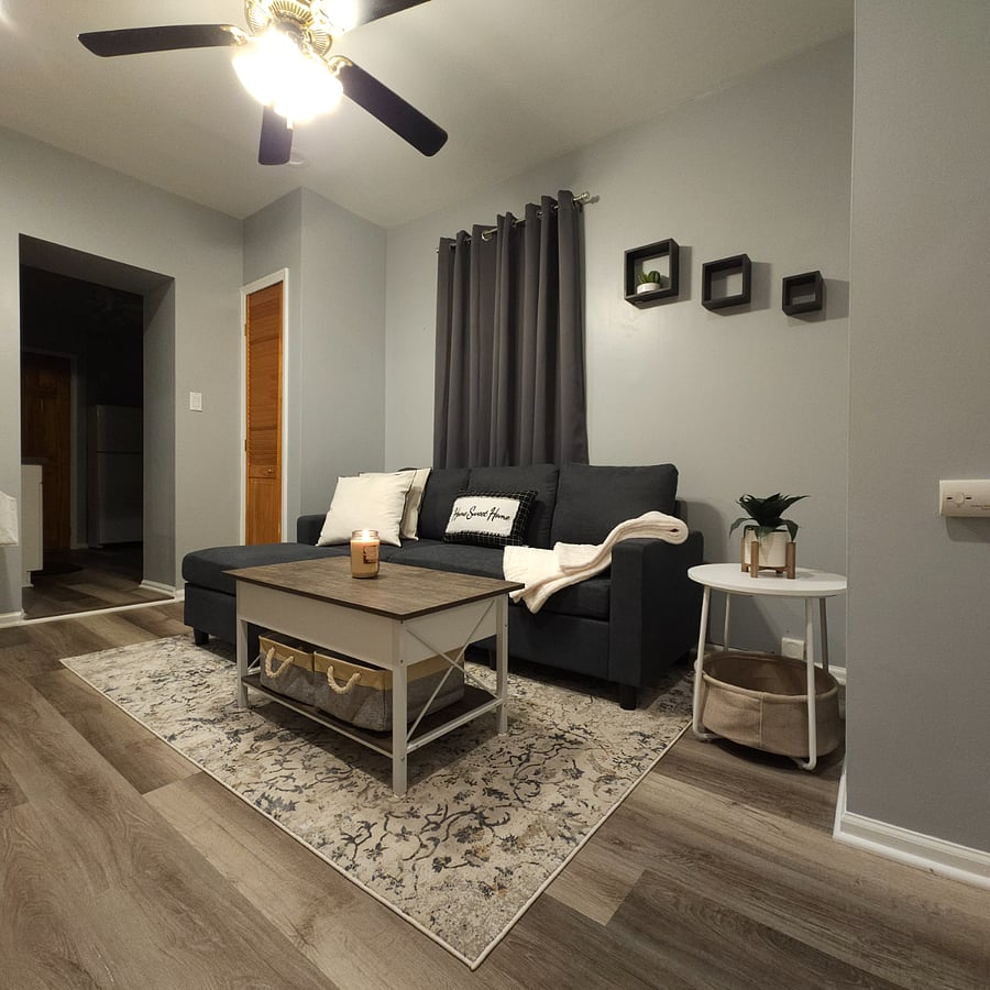 "The decor is enhanced with light-darkening shades for optimal ambiance control, alongside a versatile center coffee table that not only serves as a chic focal point but also boasts an extendable top, converting it into a dining or work table. Additionally, this innovative piece offers ample storage space, marrying functionality with style."