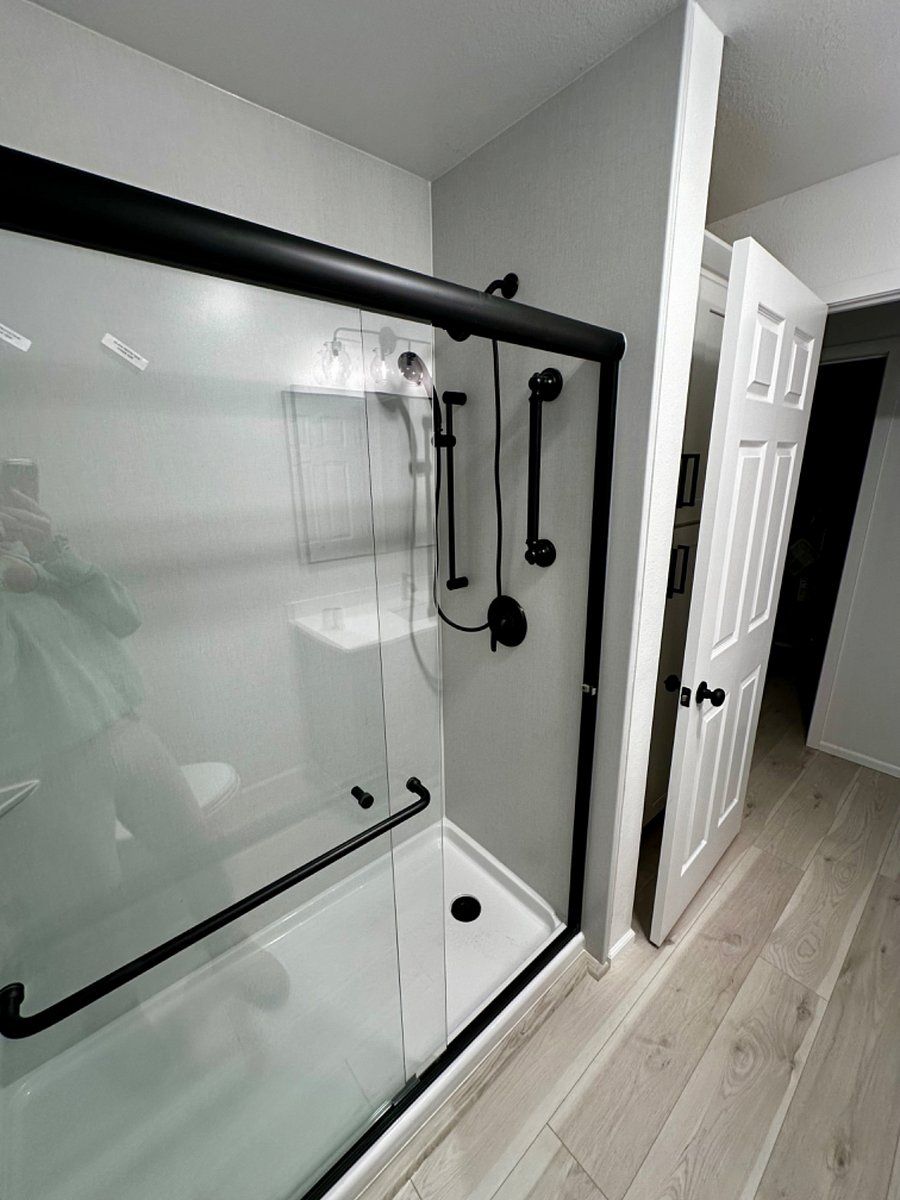 Brand new walk-in shower, hand-held with glass shower door.