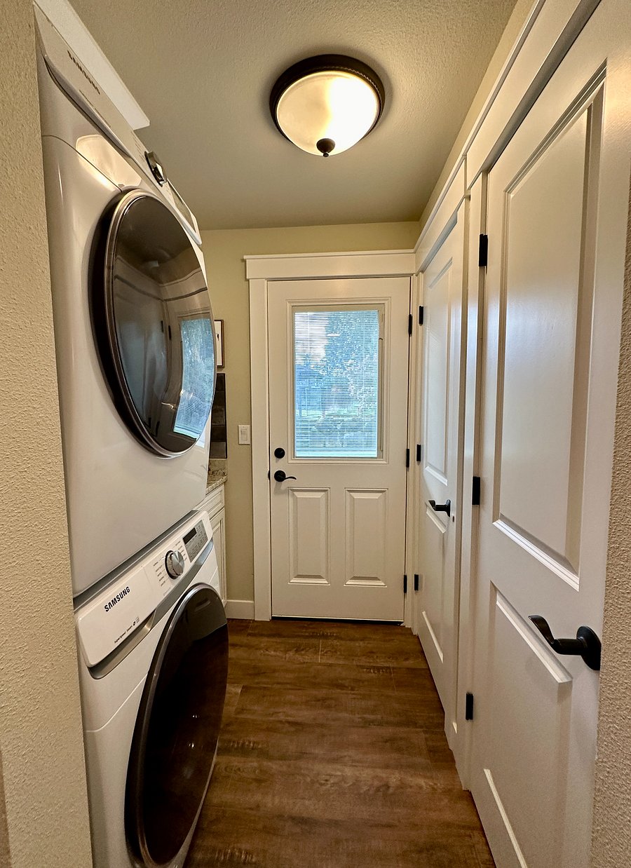 The laundry room door has access to the back yard and deck. The window allows for plenty of bright light and there are built in shades within the door for added privacy.