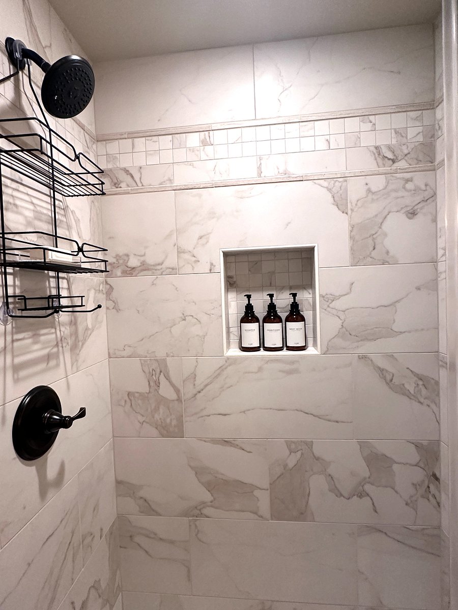 Feel pampered in this large walk-in shower featuring Italian porcelain tile and oil-bronze fixtures.