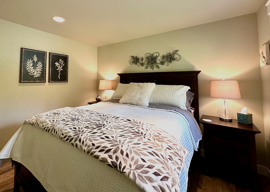 Relax in the queen bedroom in a soothing palate of neutral tones and botanical imagery. The 6 drawer storage bed allows for ample space along with the closet for all of your personal items. It features a pillow-top mattress, hotel quality sheets and cozy down comforter The door handle has a lock and separate key for your security. There is a flat screen smart TV .