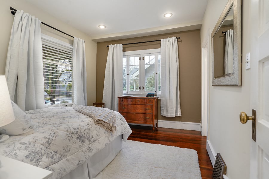 Bedroom 1: dresser and 2 windows with black out curtains.