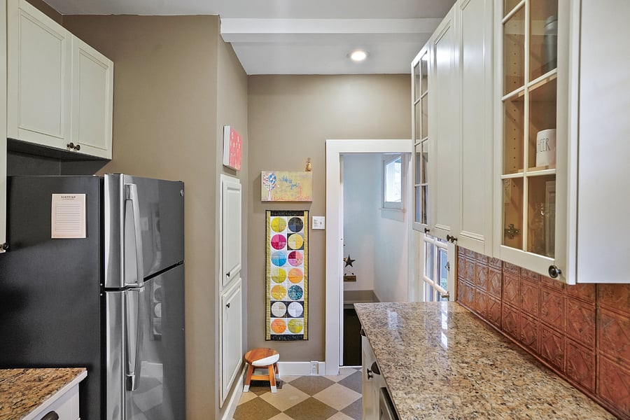 Full size fridge. Stairs leading down to the laundry room.