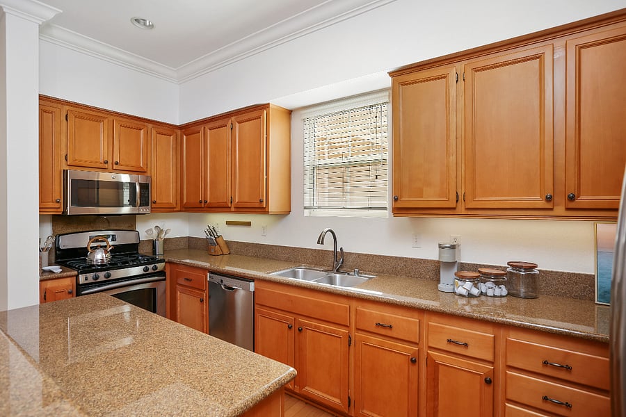Kitchen is equipped with a gas stove, microwave, dishwasher, plates, cups, silverware, cooking pots and pans.