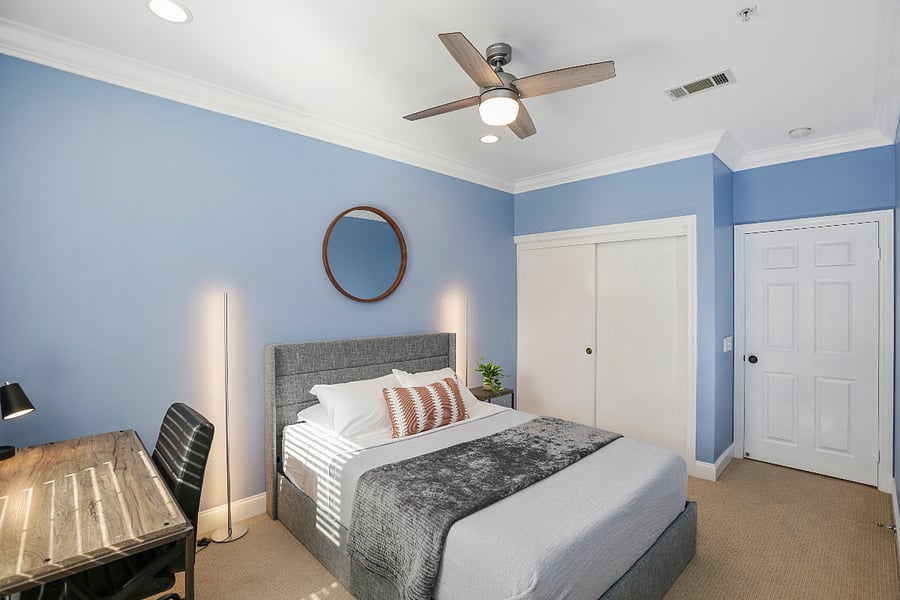Bedroom 2 with a queen size bed and dedicated workstation.