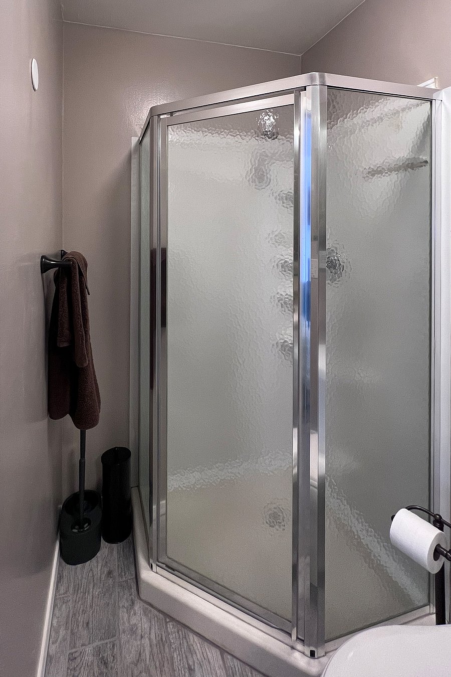 Custom-built open shelving has been added since photo was taken, turning this narrow nook between shower and wall into additional storage space for bathroom essentials.