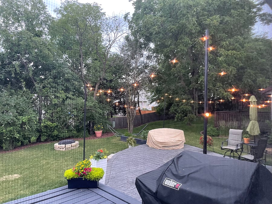 There are beautiful outdoor lights surrounding the patio and firepit area, along with seating (additional seating not pictured here)