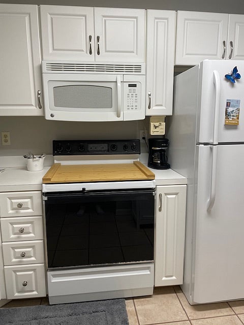 Electric stove covered by noodle board for extra counter space.  Store it beside fridge when using stovetop.