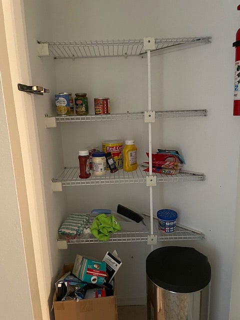 Kitchen pantry for food storage, cleaning rags, recycling and trash.