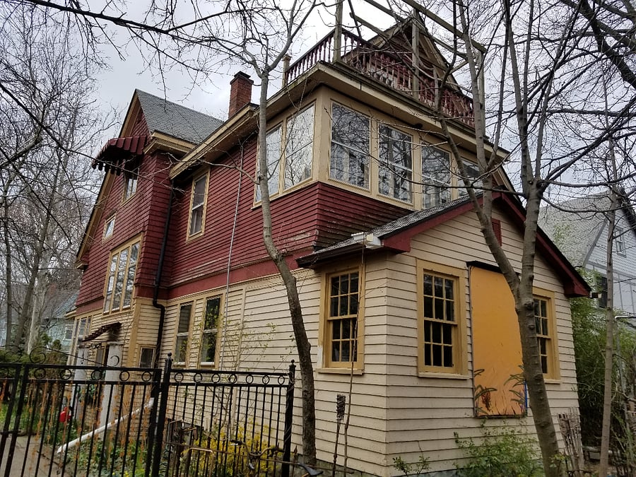 back of house shows original enclosed porch with many original rolled glass windows still intact. Referred to as a "sleeping porch' back in the days before airconditioning