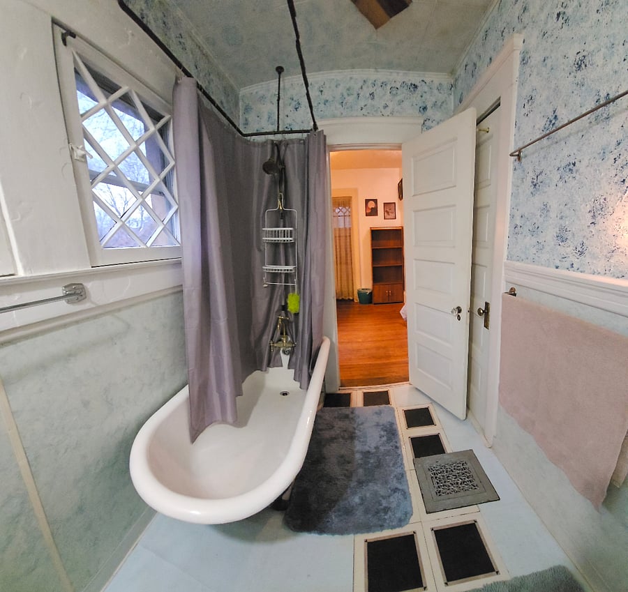 bathroom has cast iron soaking tub, vintage era brass shower