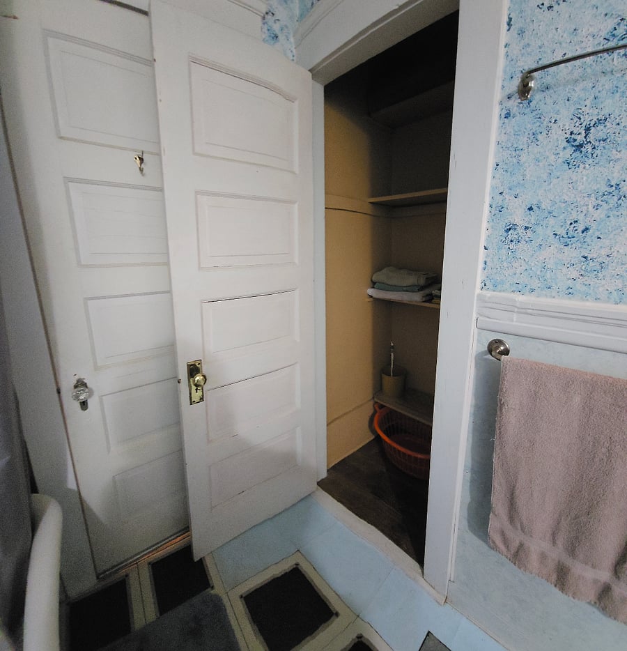 closet in bathroom holds supplies and extra linens/towels