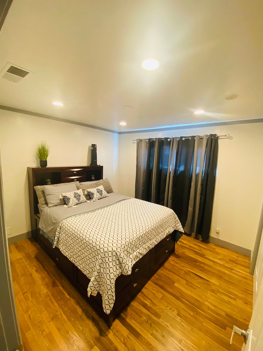 2nd bedroom with queen bed and plant of storage 