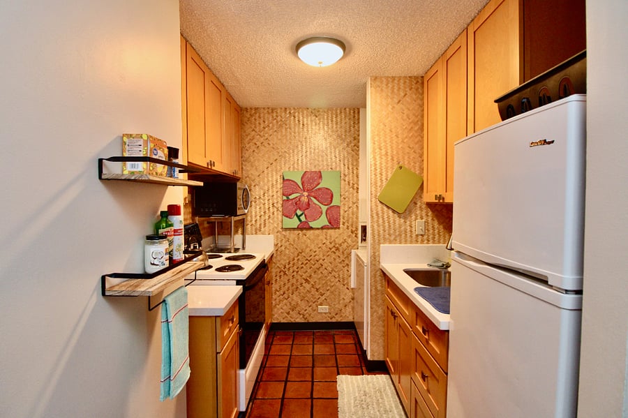 Remodeled galley kitchen, new slow close cabinets, lots of storage. Refrigerator, oven, stack washer/dryer (out of view), blender, coffeemaker, microwave, toaster oven, kitchenware, dishes.