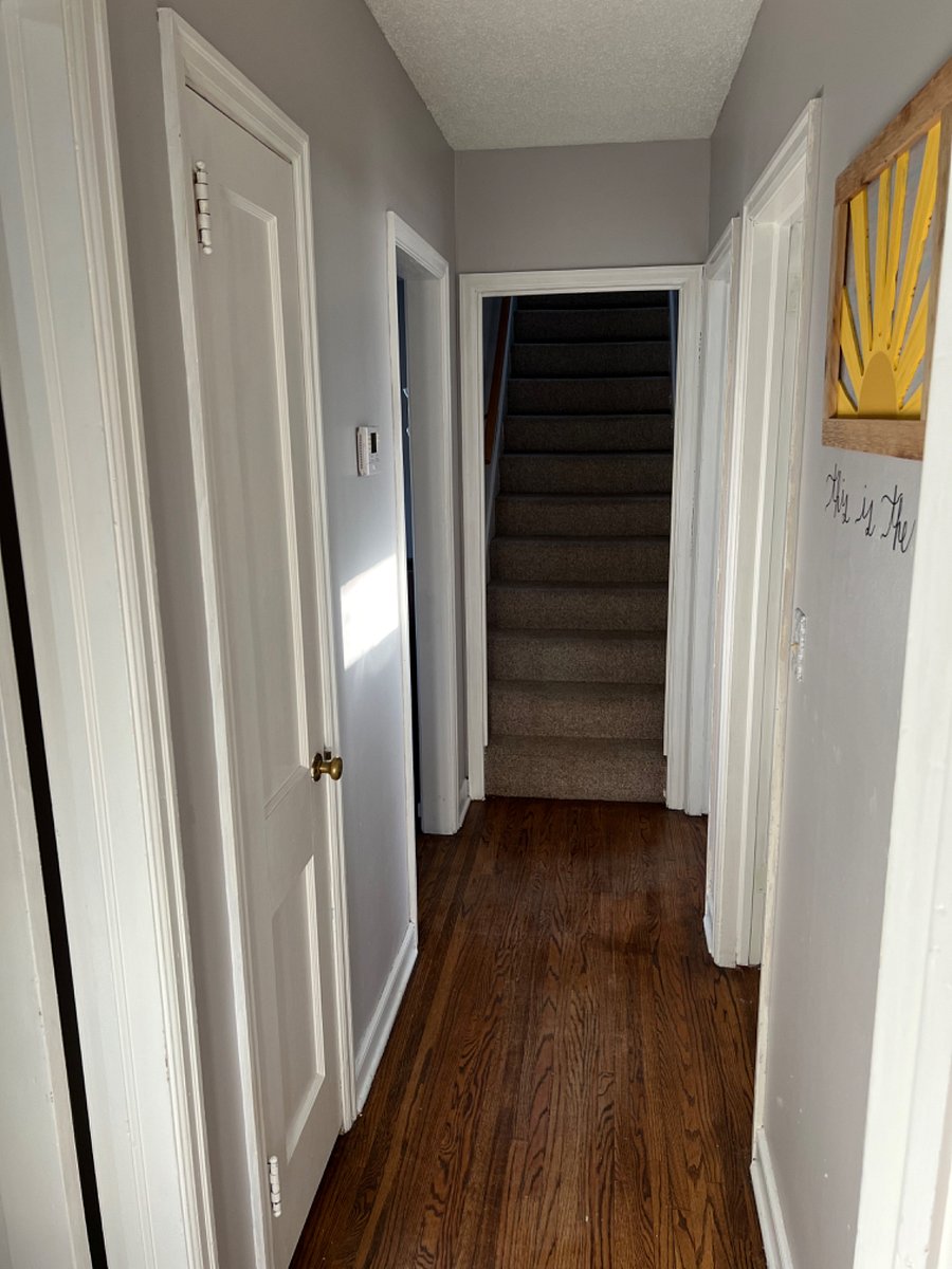 Hallway by bedrooms and bathroom, stairs to second floor