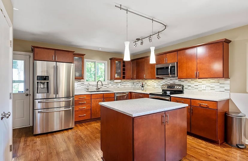 Kitchen with large refrigerator, double oven/stovetop, dishwasher, and microwave