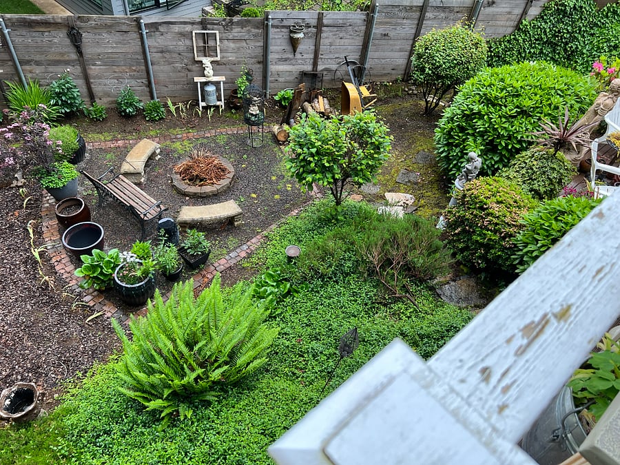 Looking down from upper deck to the back yard. Firepit and seating area.
