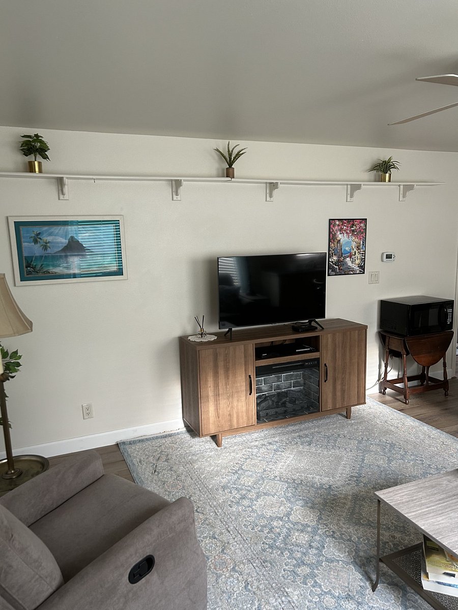 Smart TV atop an electric fireplace and heater for cozy ambiance. The cabinet also features DVD movies and games for tenant's use.