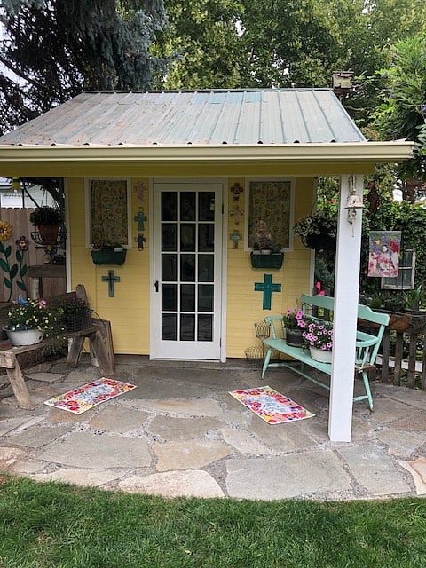 Shared backyard also includes a charming potting shed amid more spring/summer blooms.