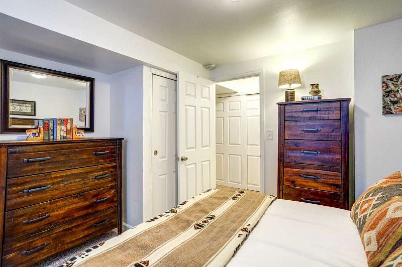 Basement bedroom with queen-sized bed and large egress window