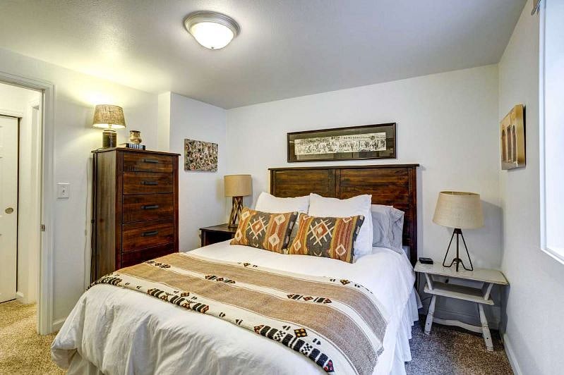 Basement bedroom with queen-sized bed and large egress window