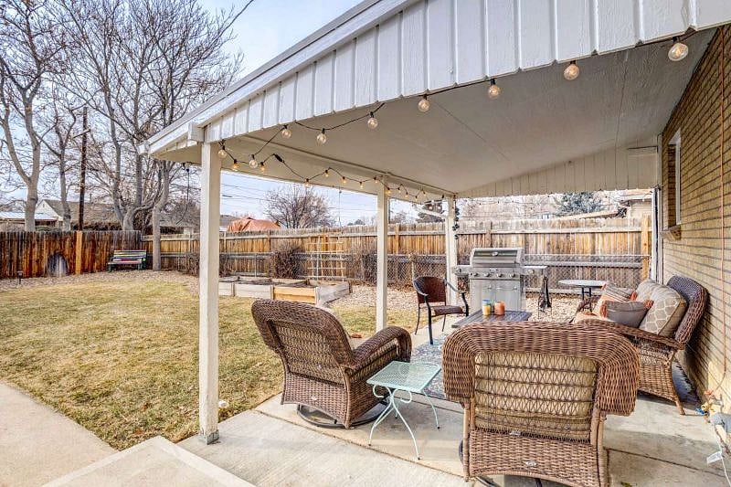 Fenced, private back yard with patio furniture, gas grill