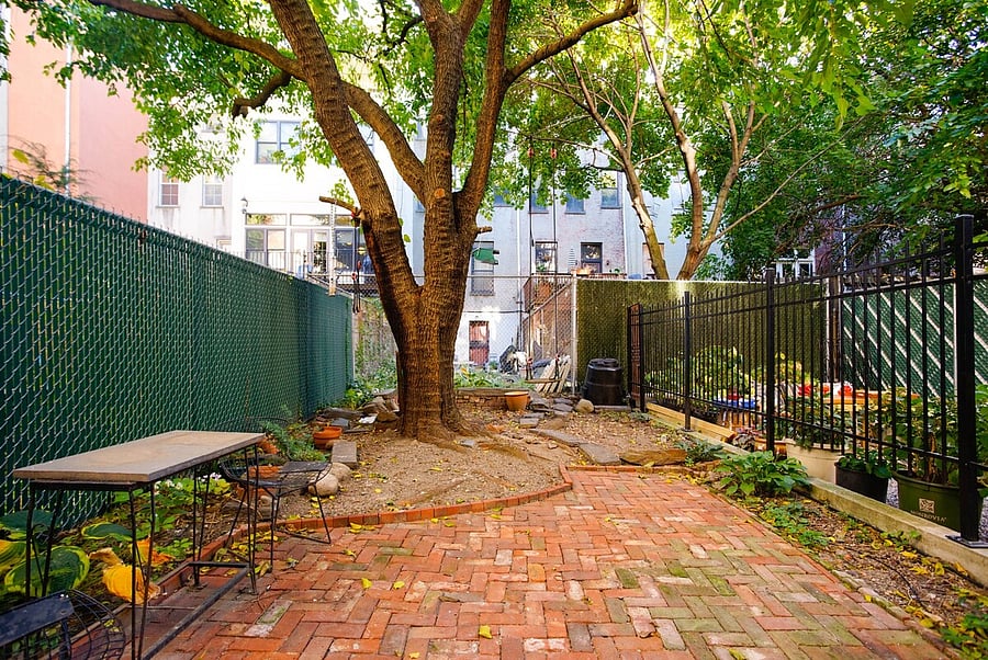 Backyard garden has grill and dining table