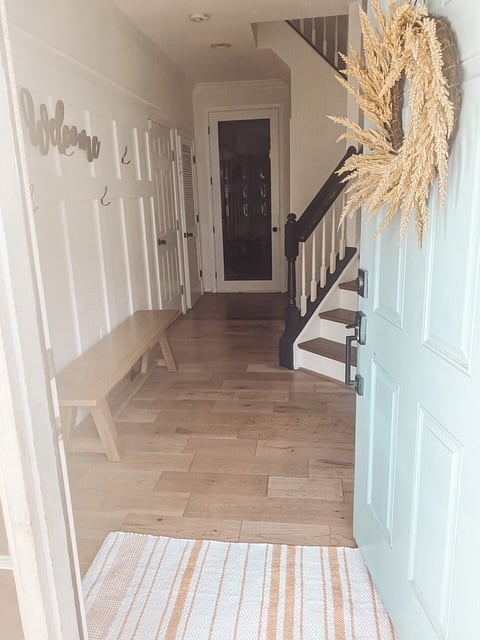 Entrance to the home and view of the door to the closed off office with work space. 