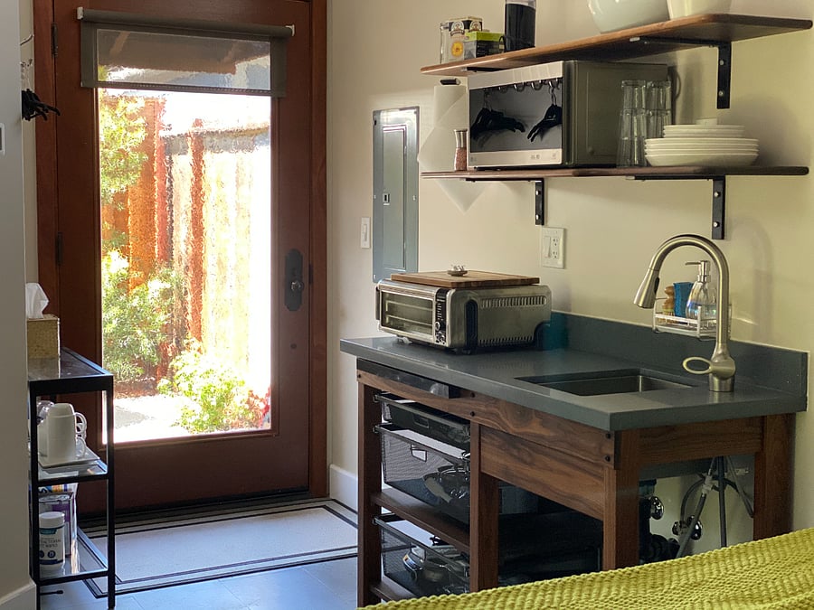 Kitchen area, microwave, hot plate, Cuisinart AirFryer, coffee maker, electric kettle. Dishware, flatware, glassware.