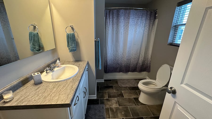 Master bathroom with linen closet behind door