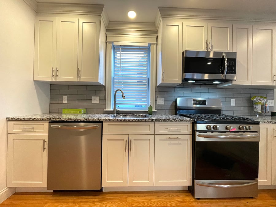The well-designed kitchen has matching stainless steel appliances (gas oven!) and a black, white and gray granite countertop
