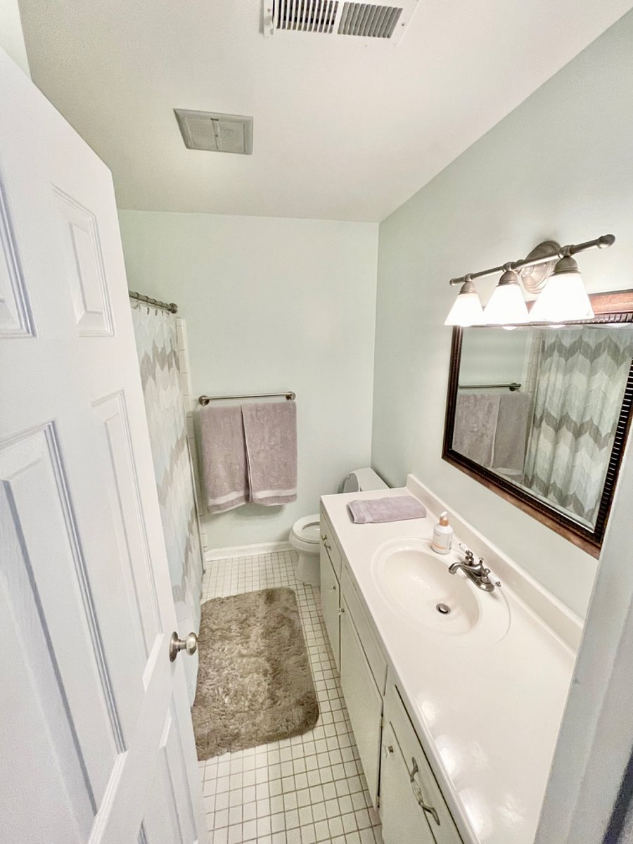 Hall bathroom with tub shower, linen closet and large vanity