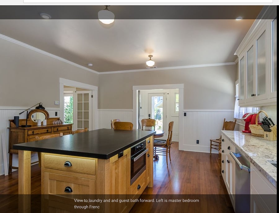 Kitchen looking out to patio. Laundry to left and powder room to right