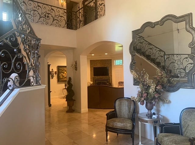 Foyer entry with 26' Ceilings and grand wrought iron staircase.