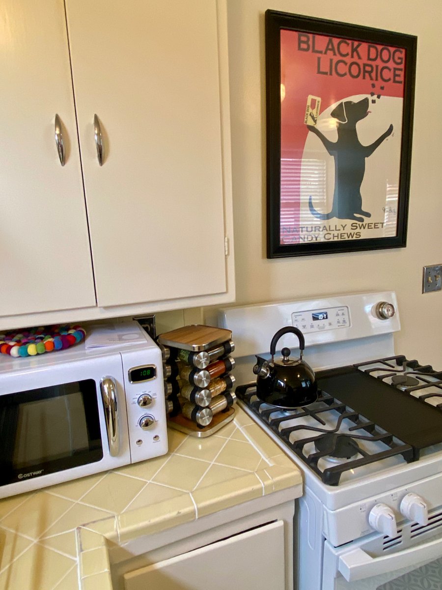 Retro kitchen with 5 burner stove, microwave, spice rack, tea kettle and all the items you need to enjoy cooking meals at home.