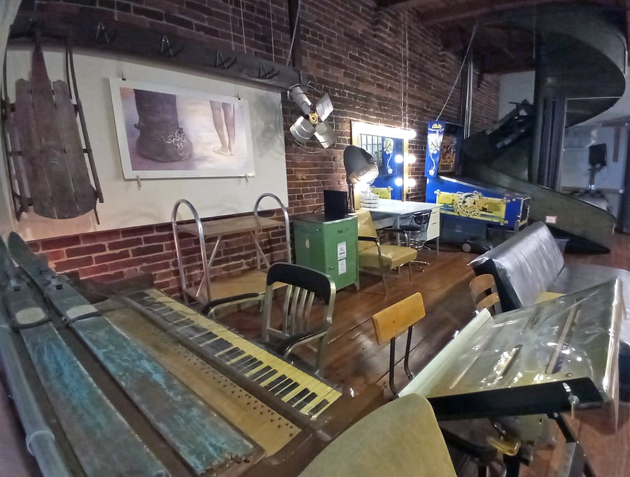 Here is a dynamic workspace showcasing another drafting table or laptop desk and a deconstructed piano, offering a versatile and creative environment.