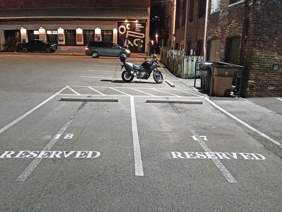 Discover your parking space, #17, located just beyond the end of the building and conveniently positioned right in front of the trash and recycling bins.