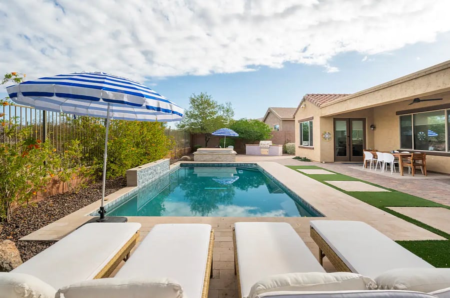 Backyard space w/ pool, hot tub, lounge chairs, outdoor dining table