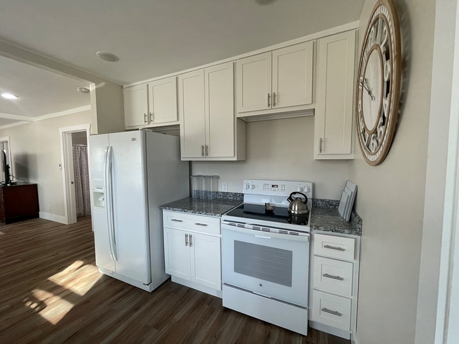 Kitchen with a full side by side refrigerator and a new range.